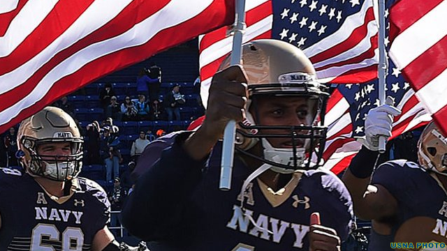 Navy football players with U.S. Flag